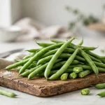 Fresh green french beans piled on a wooden board