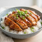 Teriyaki chicken rice bowl with sesame seeds and green onions